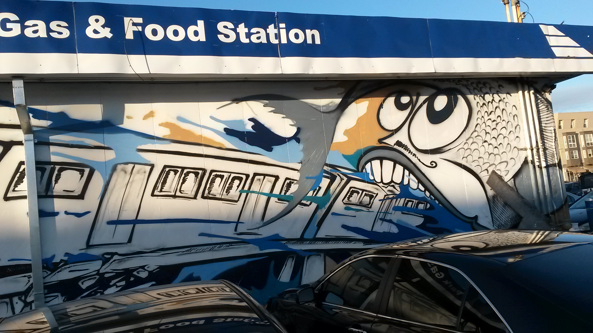 street art image of a train driving into the mouth of a giant fish